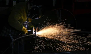 Man using an angle grinder on some steel