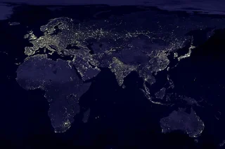 Stylised image of the globe at night with pinpricks of light dotted throughout major cities